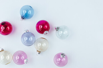 Christmas balls made of transparent glass of different colors on a white background. taken from above