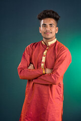Obraz premium Portrait of a happy young man posing with arms crossed or hands folded on a dark background