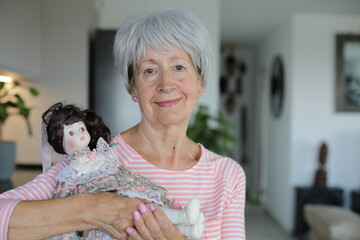 Senior woman holding an interesting porcelain doll 
