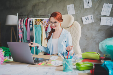 Photo of shop assistant girl sit in office store using netbook for talking client