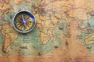Classic round compass on background of old vintage map