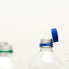 Attached lids on PET bottles on monochrome background