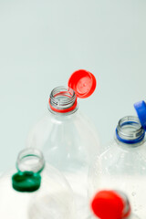 Attached lids on PET bottles on monochrome background