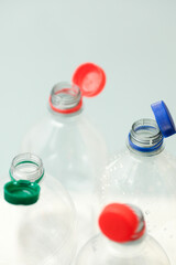 Attached lids on PET bottles on monochrome background