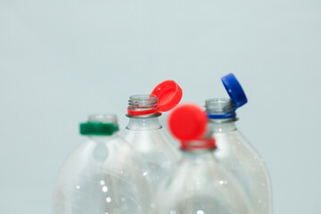 Attached lids on PET bottles on monochrome background