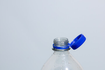 Attached lids on PET bottles on monochrome background