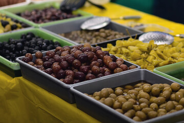 Trays of processed olives on display for sale in a supermarket