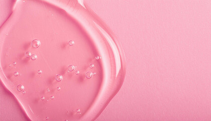 Transparent hyaluronic acid gel texture on pastel pink backdrop. Serum for skincare. Beauty concept.