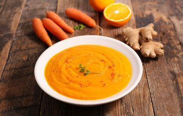 carrot and orange soup on wood background