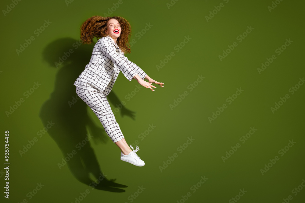 Canvas Prints Full size photo of pretty young girl jumping pushing invisible things wear trendy white plaid outfit isolated on khaki color background