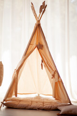 Close-up of wigwam at home . The cozy sand stylish furnishing in the apartment in biege shades © Вероника Зеленина