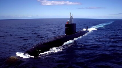 Fototapeta premium A black submarine surfaces in the open ocean, leaving a white wake in its path.