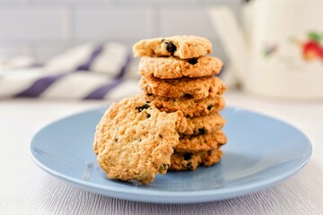 Oat cookies blackcurrant in a blue ceramic plate on white blackground