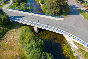 Reinforced concrete road bridge over the river. Close-up during sunny day in summer. Aerial view on...