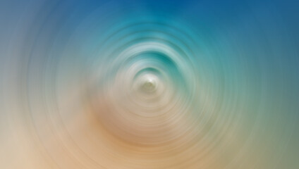 A blurred, circular motion effect image featuring soft tones of blue, green, and beige, resembling a serene abstract scene with a calming gradient.