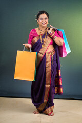 Beautiful Indian woman holding and posing with shopping bags