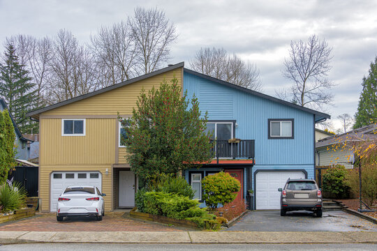 Duplex residential house with cars parked in front on autumn season in British Columbia