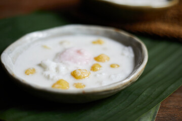 Thai glutinous rice balls with coconut milk on wood