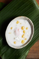 Thai glutinous rice balls with coconut milk on wood