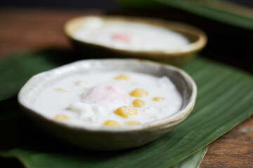 Thai glutinous rice balls with coconut milk on wood