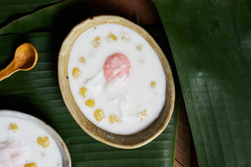 Thai glutinous rice balls with coconut milk on wood
