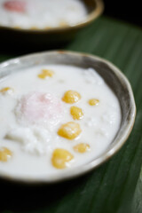 Thai glutinous rice balls with coconut milk on wood