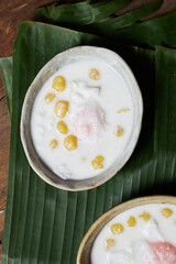 Thai glutinous rice balls with coconut milk on wood