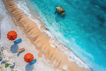 Fototapeta premium Beach umbrellas and chairs on a sandy shore. This is an aerial view of a beach perfect for summer vacation, advertising or travel blogs.