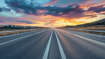 Fototapeta premium empty highway at dusk, with the sky painted in vibrant colors, emphasizing the peacefulness of the open road.