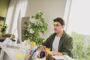Photo of bored upset man accountant working hard modern pc drink coffee low energy workplace...
