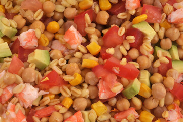 Salade composée maison avec des pois chiches, des crevettes, du maïs, du blé, des tomates et du concombre en gros plan