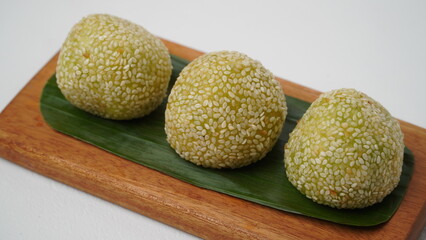 Crispy sesame ball with lotus paste or onde-onde on wooden plate isolated on white background