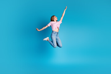 Full size photo of pretty young girl raise hand jumping empty space wear trendy pink striped outfit...