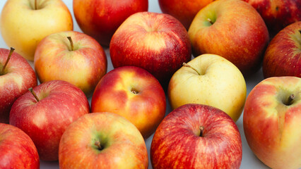 fresh apples, showcasing their vibrant red and yellow skins. The apples are arranged closely together, highlighting their crisp texture and natural appeal