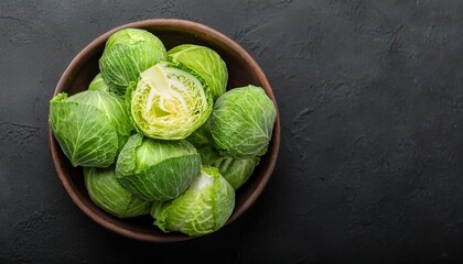 green cabbage in a bowl on a black background, top view, copy space 