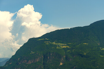 A Majestic Mountain Range Basking Under a Fluffy Cumulus Cloud in a Sunny Summer Sky