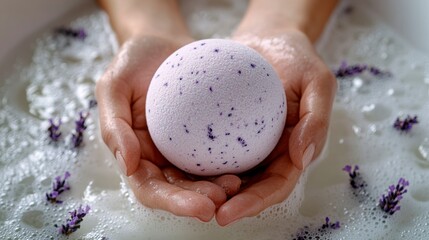 Woman holding a lavender bath bomb in a bubble bath