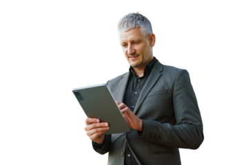 A focused businessman in a grey suit uses a tablet, concentrating on the screen with a serious expression.
