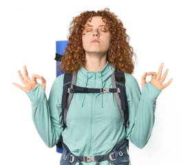 Young Caucasian redhead ready for hiking relaxes after hard working day, she is performing yoga.