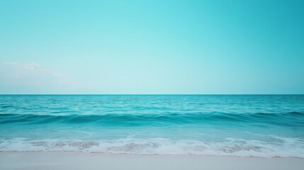 Fototapeta premium Turquoise ocean waves gently lapping on the shore, a peaceful and vibrant background for beach and tropical themes