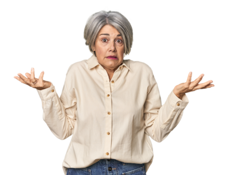 Caucasian mid-age female on studio background doubting and shrugging shoulders in questioning gesture.