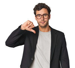 Young Hispanic businessman showing a dislike gesture, thumbs down. Disagreement concept.