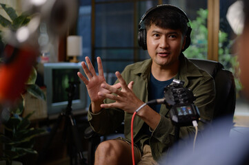 Two hosts of podcasts a happy radio host in a chic studio, one speaking into the microphone as the other listens intently while donning headphones to record a podcast.