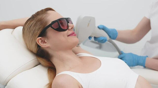 Underarm laser hair removal in a beauty clinic. A professional cosmetologist performs a precise treatment to remove unwanted hair from a young woman's armpits, ensuring smooth results.
