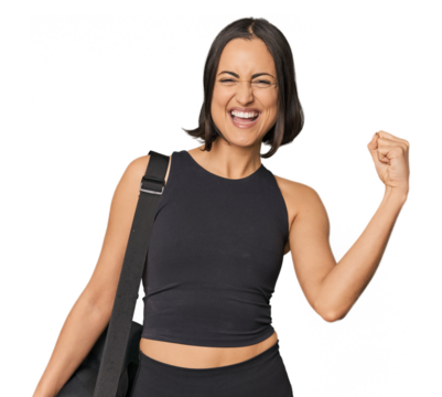 Young Caucasian sportswoman with backpack raising fist after a victory, winner concept. - Powered by Adobe