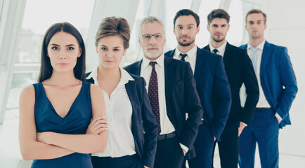 Successful serious business people standing in row in office