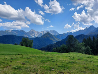 Fototapeta premium Mountains under blue sky. Logar Valley. Green nature of Slovenia. Kamnik–Savinja Alps.