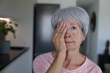 Senior woman testing her vision covering just one eye 