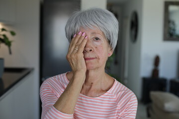 Senior woman testing her vision covering just one eye 
