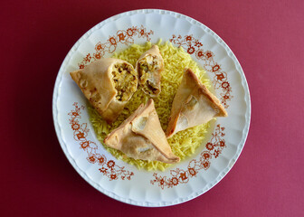 Samosas on a bed of saffron rice.